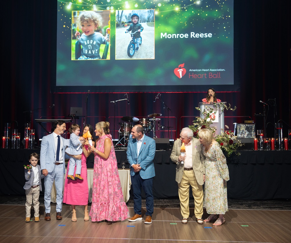 Survivor families on stage with Emcee holding up torches.